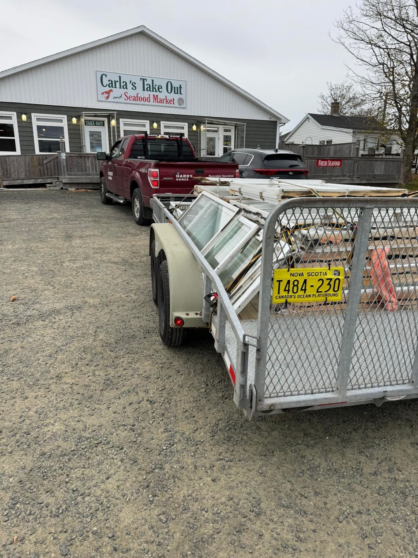 Hardy truck and trailer loaded with replacement windows on a job site