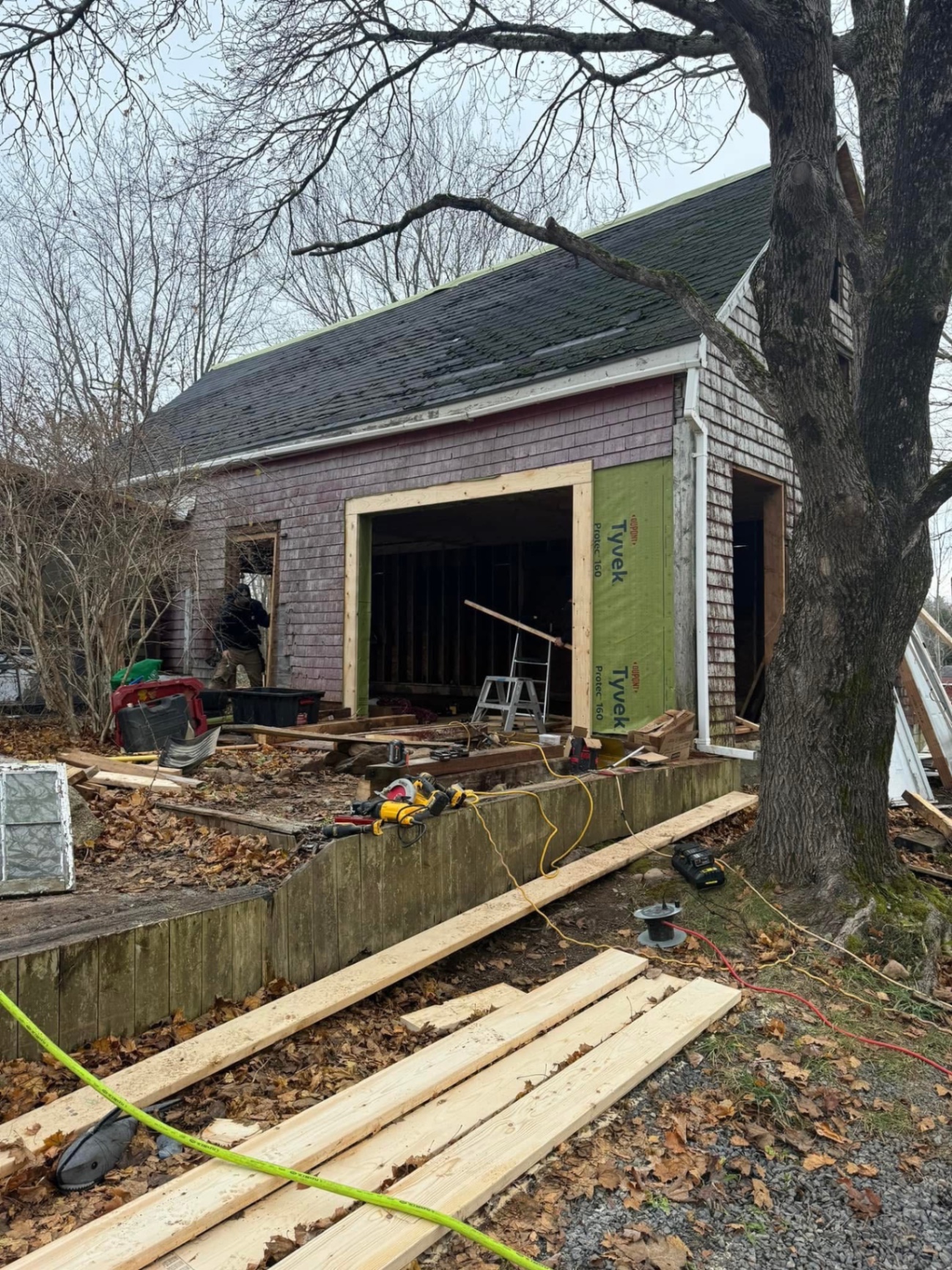 Old shingle home with framed openings ready for new windows and doors