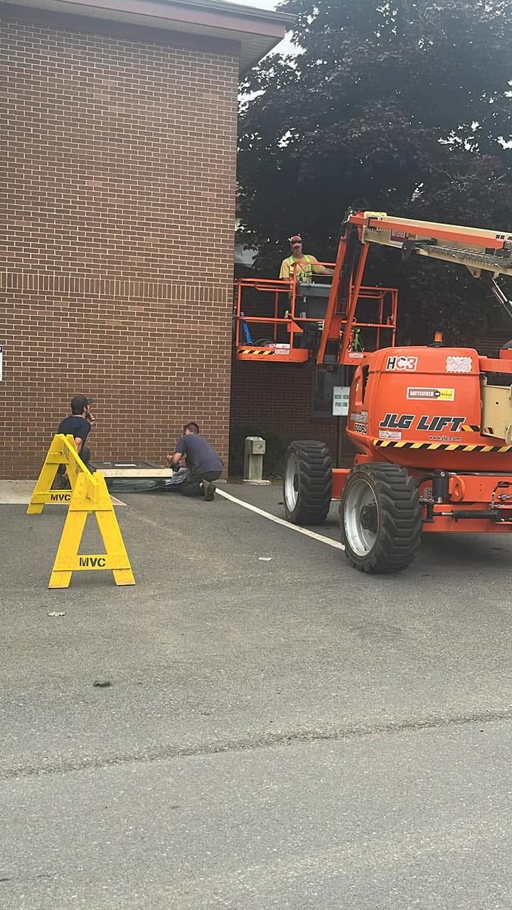 Commercial window installation with a lift at a brick building