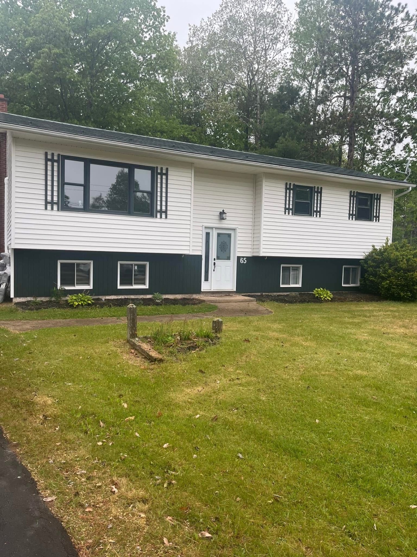 Finished split-entry home with new black windows and white siding